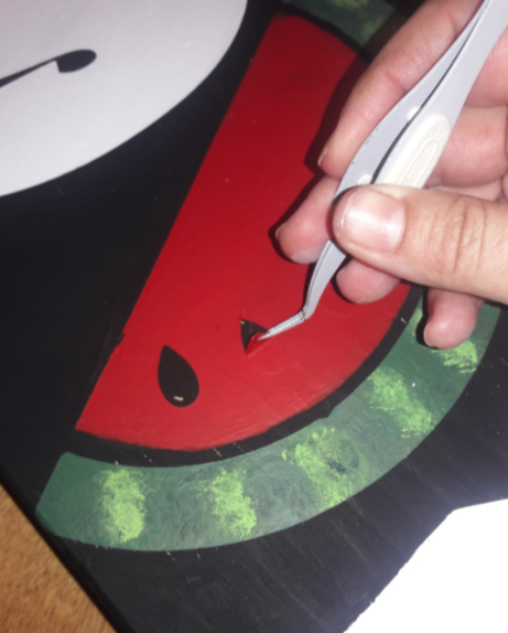Using tweezers to peel off the smaller parts of the stencil